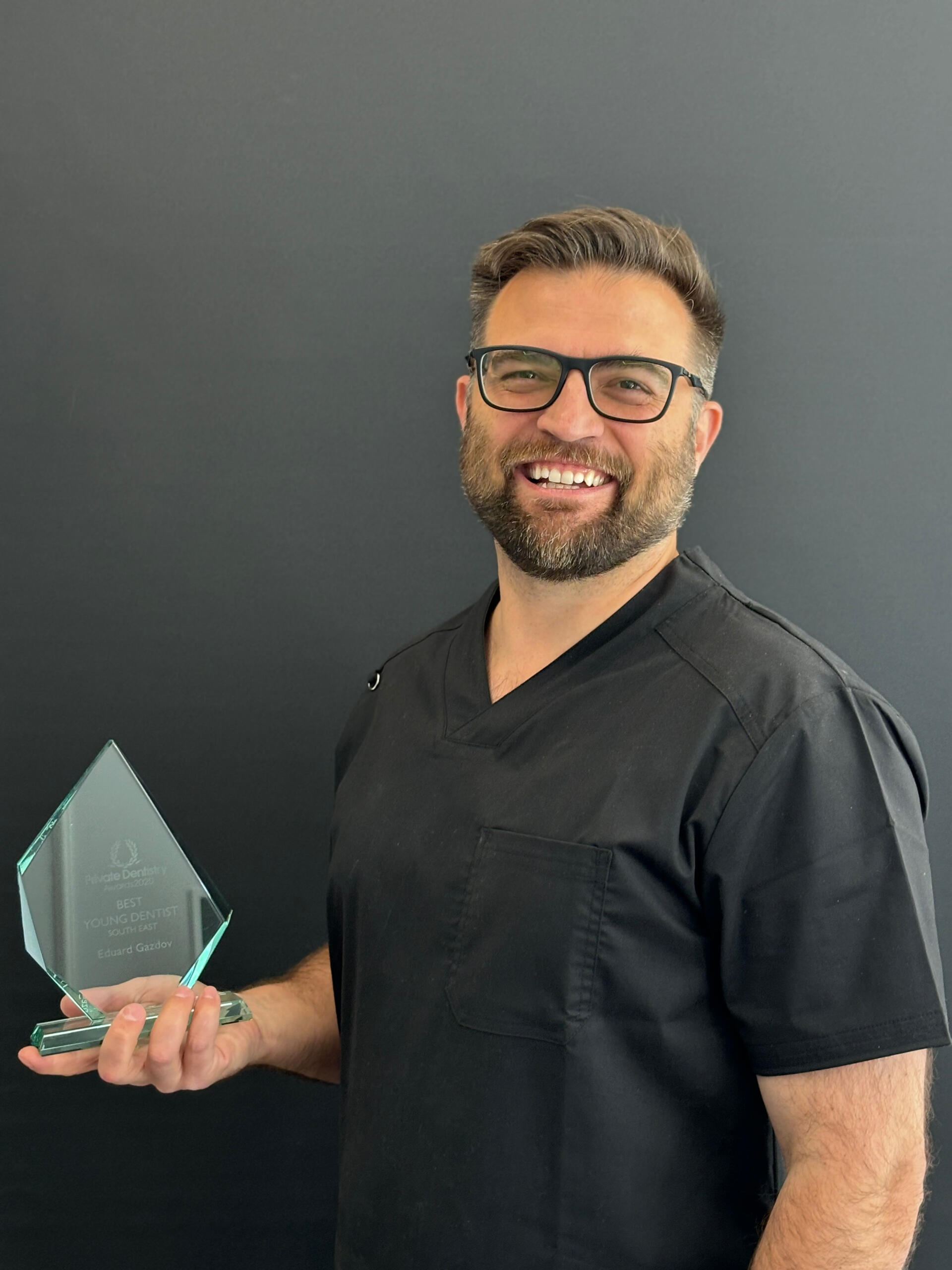 Dr Eduard Gazdov holding the Best Young Dentist UK 2020 (South East) award, recognised among top peers in British dentistry.